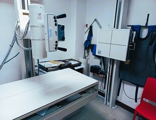 Modern X-ray machine with a technician in a professional setting. Highlight the advanced technology and clean environment. Focus on precision and reliability.
